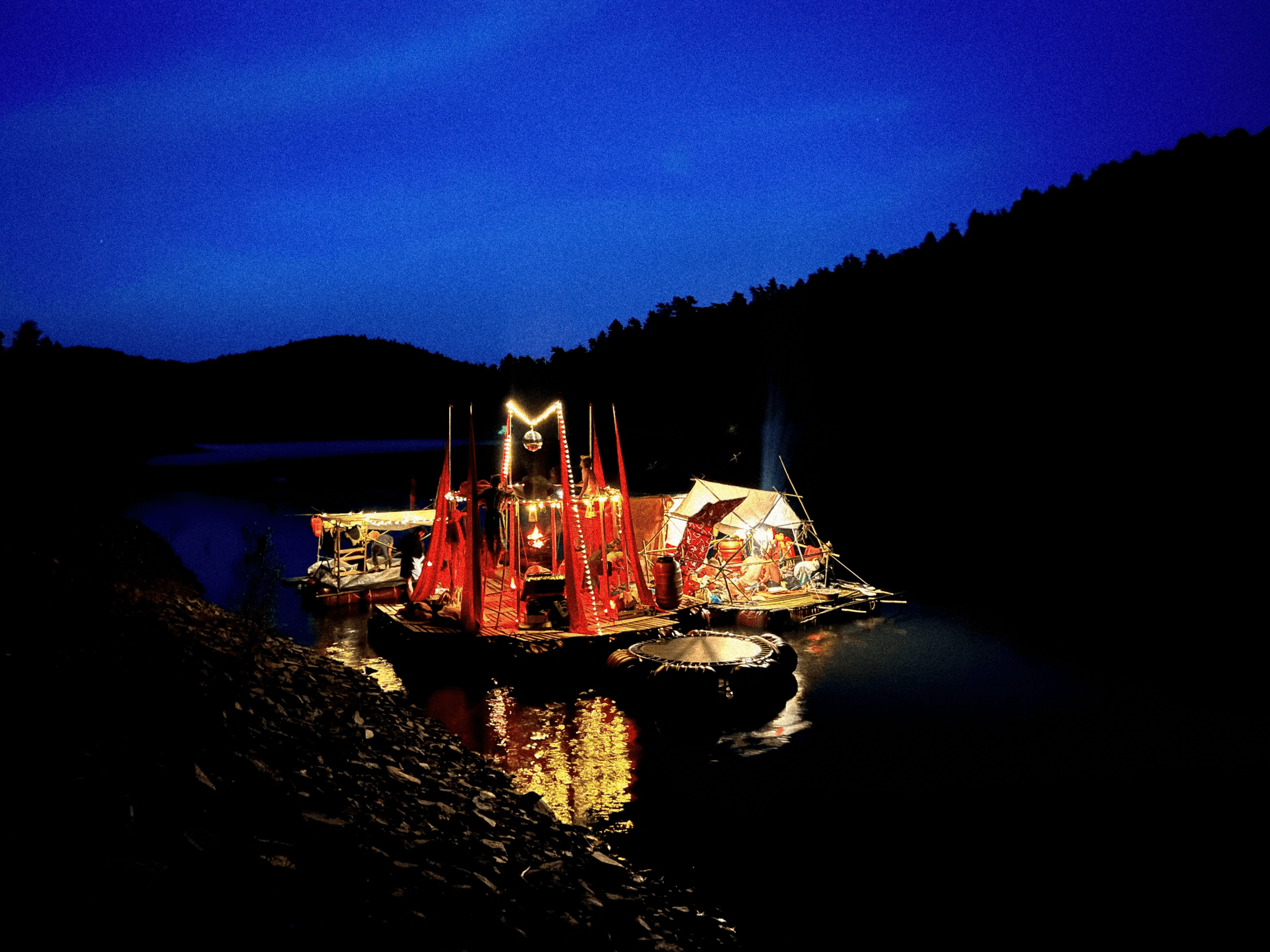 Un radeau illuminé sur le lac la nuit